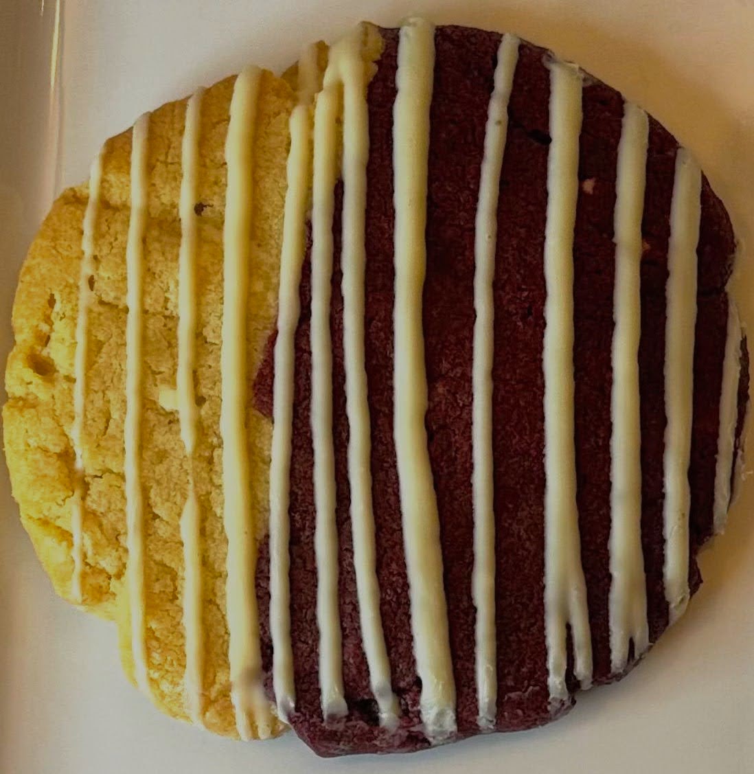 Red velvet cookie with white chocolate chips and a smooth white chocolate drizzle, perfect for Valentine's Day or any special occasion.