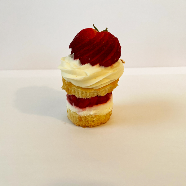 Strawberry Shortcake stacked cupcake: Vanilla cupcake split and filled with homemade whipped cream and fresh chopped strawberries and topped with homemade whipped cram and whole sliced strawberry