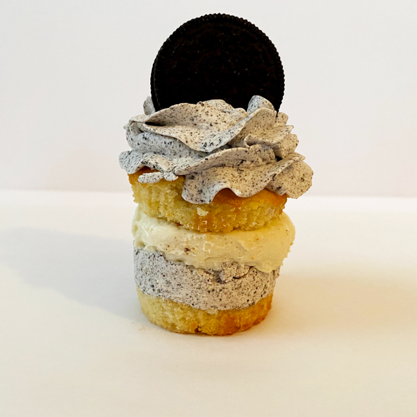 Cookies & Cream stacked cupcake: Vanilla cupcake split and filled with Oreo italian meringue buttercream and cheesecake mousse and topped with Oreo italian meringue buttercream and Oreo cookie 